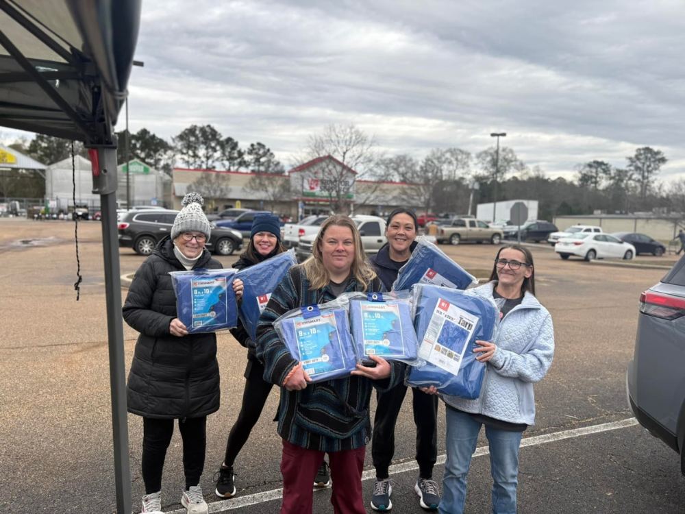 PALS Rescue volunteers holding fundraiser materials at a community event in McComb, Mississippi